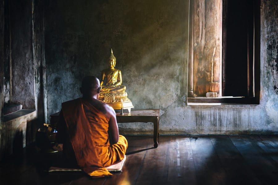 Buddhist monk in front of Hindu statue