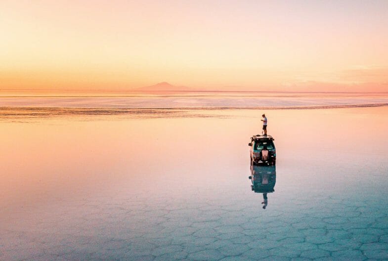 fotógrafo sobre un coche al atardecer