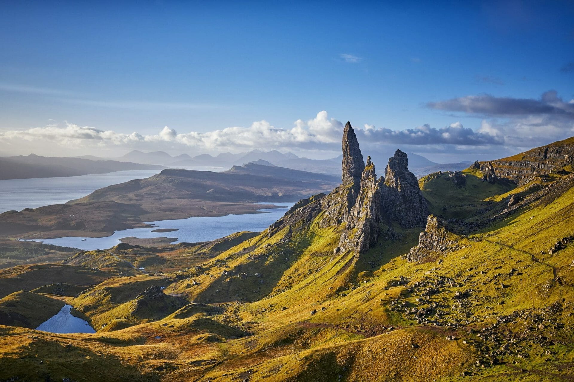 Vista sobre el Old Man of Storr, en la Isla de Skye, Escocia, durante un hermoso amanecer y un cielo dramático con algunas lluvias locales aquí y allá. El Old Man of Storr se alza sobre Portree, en la Isla de Skye, y está situado a 7 millas al norte de la ciudad. Está dominado por el pináculo de lava petrificada del Old Man of Storr, de 50 metros de altura, con un escarpado acantilado detrás, y el panorama se extiende a través de lochs, mares e islas hasta las montañas del continente más allá.